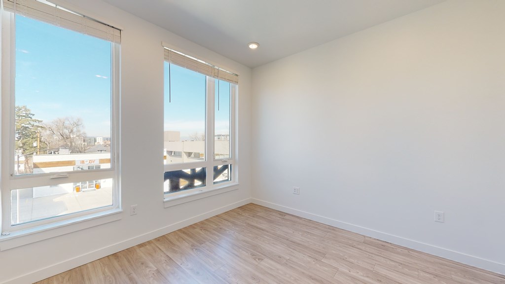A room with a large window and wooden flooring.