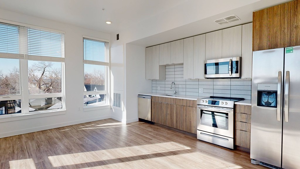 A modern kitchen with a refrigerator, oven, and microwave.