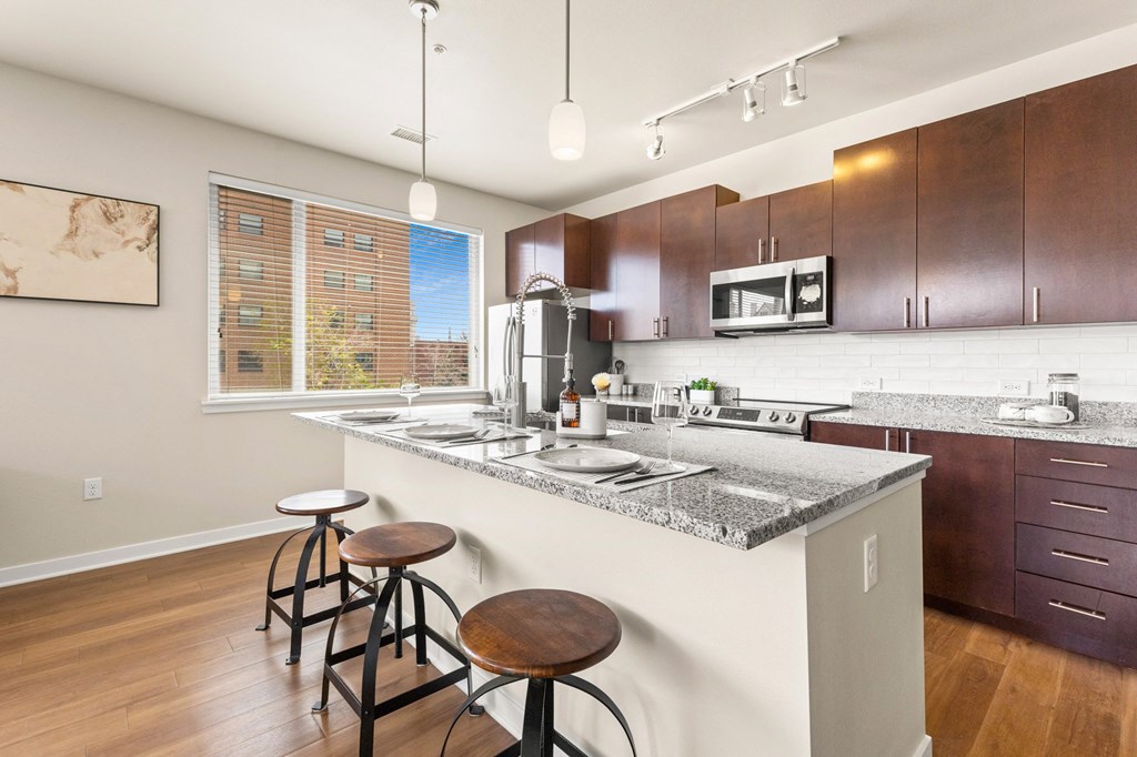 a kitchen with a counter top with three stools