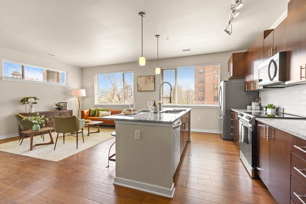 a large kitchen with an island and a dining room with a table and chairs