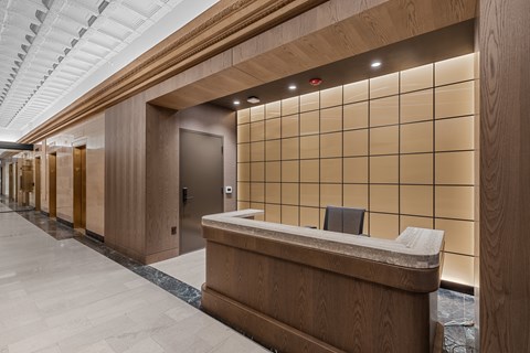 A reception area with a wooden counter and a tiled wall.