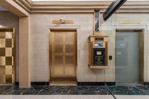 A golden elevator door with a sign that says "Letters" on it.
