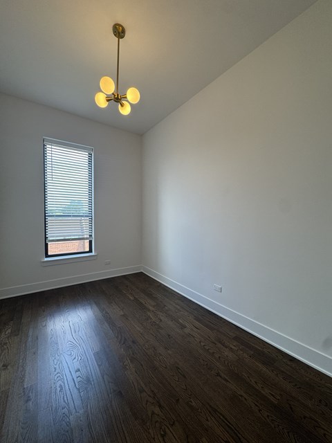 A room with a window and a wooden floor.