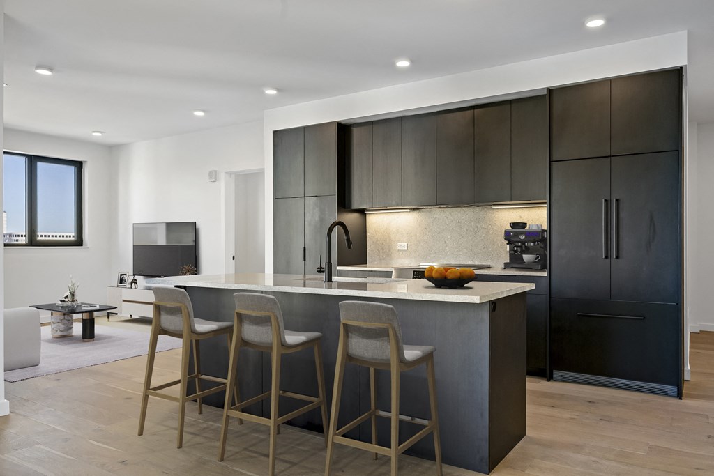a kitchen with a large island with three chairs in front of it