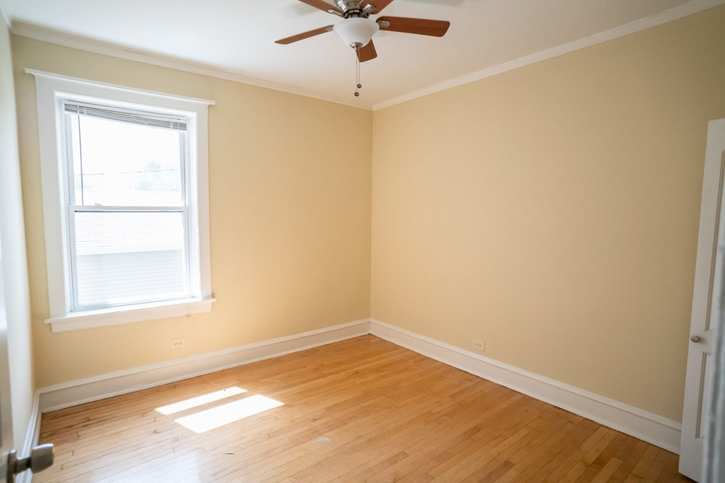 an empty room with a ceiling fan and a window