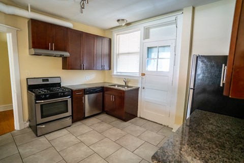 an empty kitchen with a refrigerator and a sink