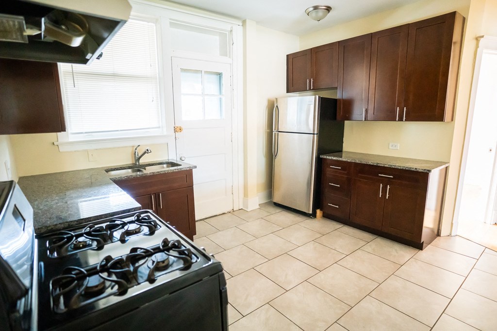 an empty kitchen with a stove and a refrigerator