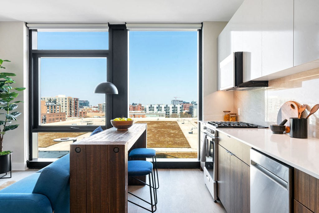 a kitchen with a large window and a counter and a blue couch