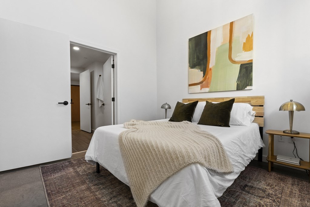 a bedroom with a bed and a painting on the wall