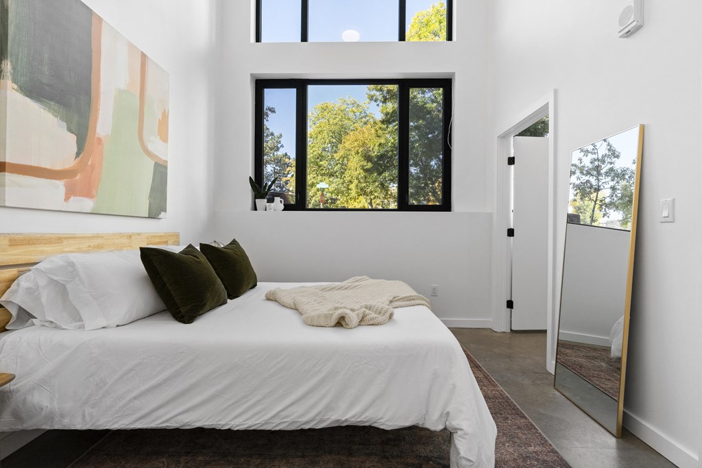 a bedroom with a bed and a large window