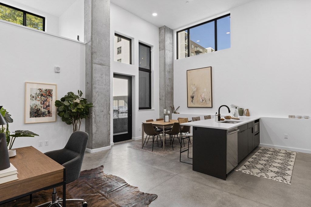 a living room with a kitchen and a dining area with a table and chairs