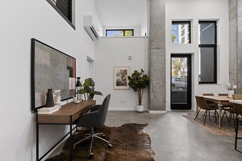 a home office with a desk and a chair in a room with a large window