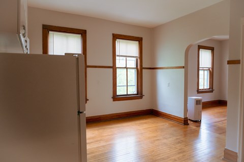 A room with wooden floors and two windows.