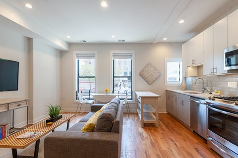 A modern living room with a grey couch and a wooden coffee table.