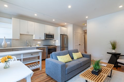 a living room and kitchen with a couch and a table