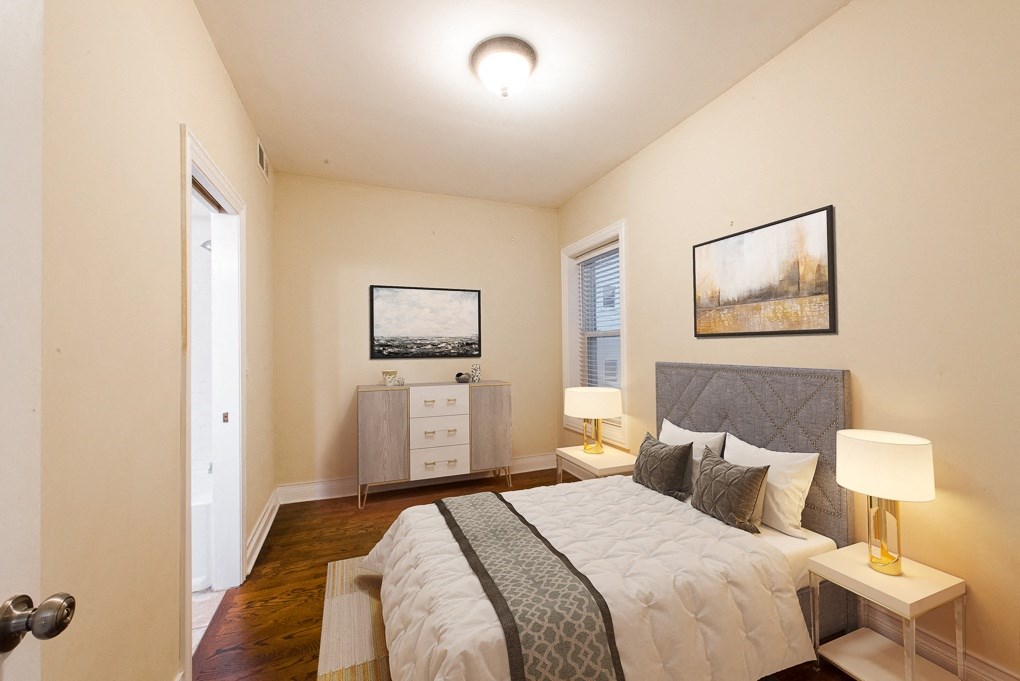 a bedroom with a bed and a dresser and a window