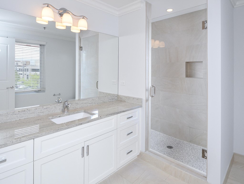 a white bathroom with a sink and a shower