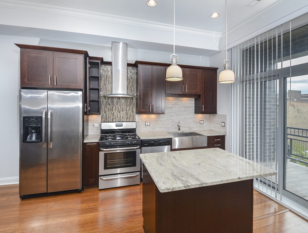 a kitchen with stainless steel appliances and a marble counter top