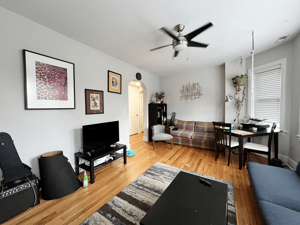 a living room with a couch and a ceiling fan