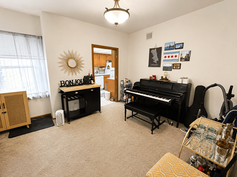 A room with a piano, a drum set, and a guitar.