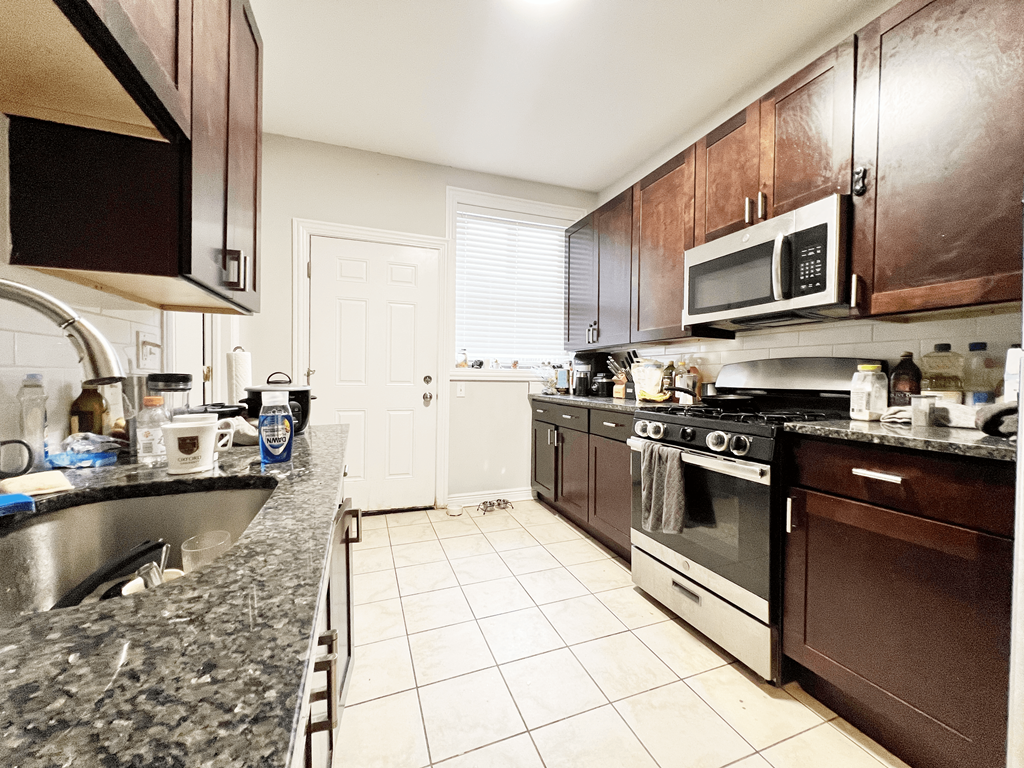 a kitchen with wooden cabinets and granite counter tops