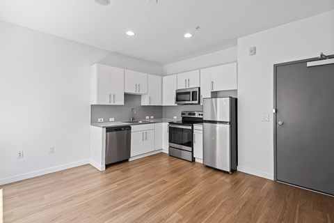 A kitchen with stainless steel appliances and wooden floors.