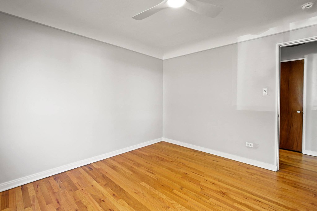 a living room with white walls and wood floors