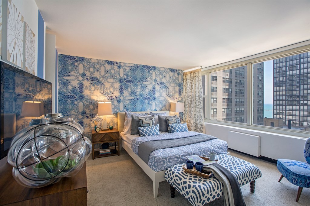 a bedroom with blue and white wallpaper and two beds