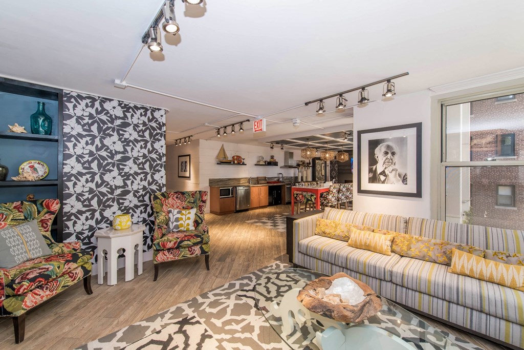 a living room with a couch and chairs and a kitchen