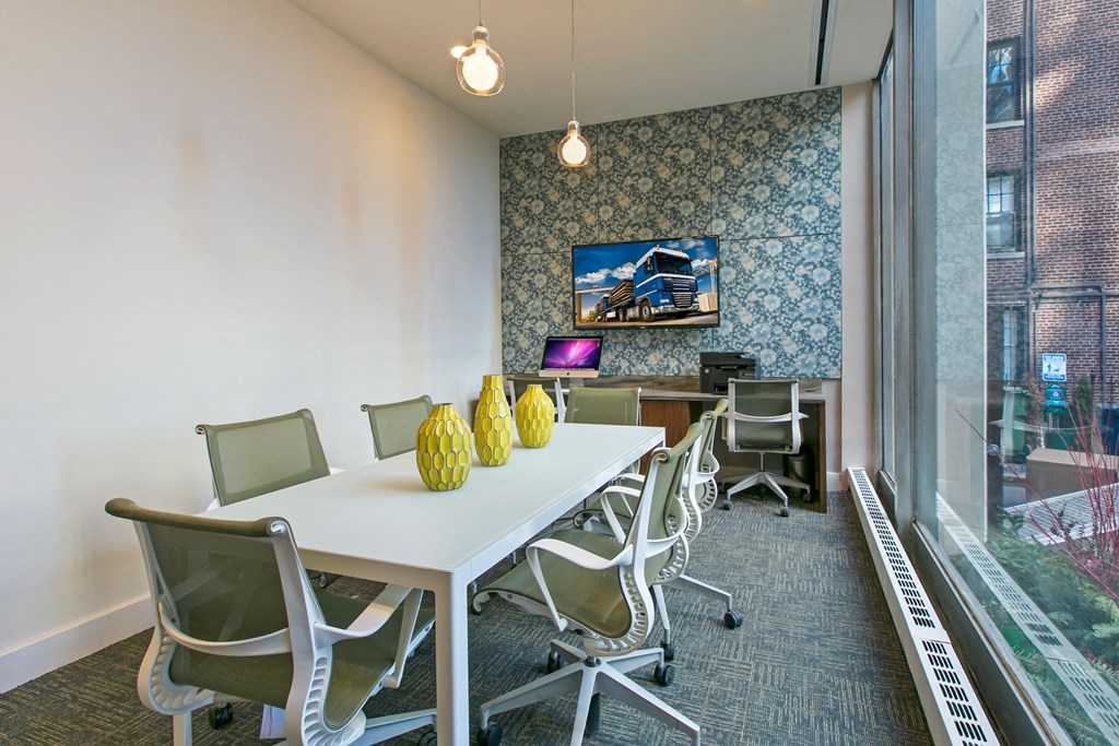 a conference room with a white table and chairs and a large window