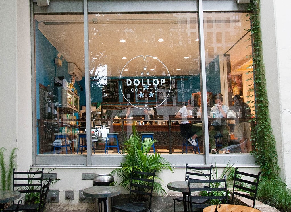 a window view of a restaurant with tables and chairs