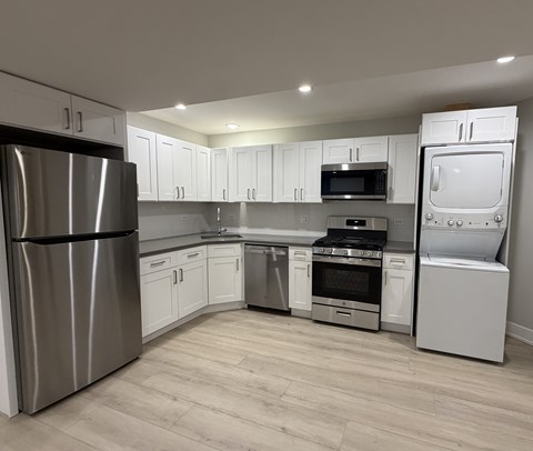 A modern kitchen with stainless steel appliances and white cabinets.