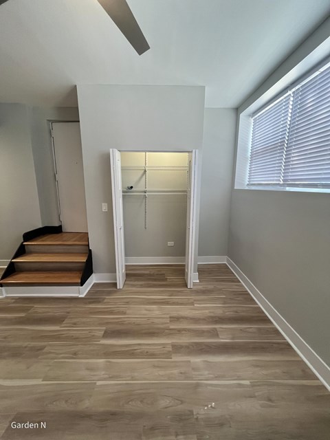 A room with a staircase and a door leading to another room.