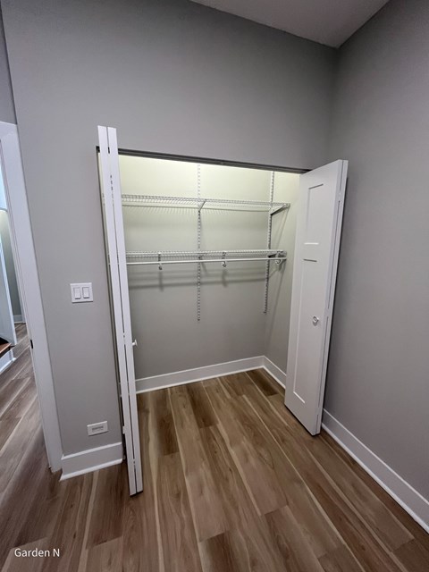 A white pantry with a white door open and shelves inside.