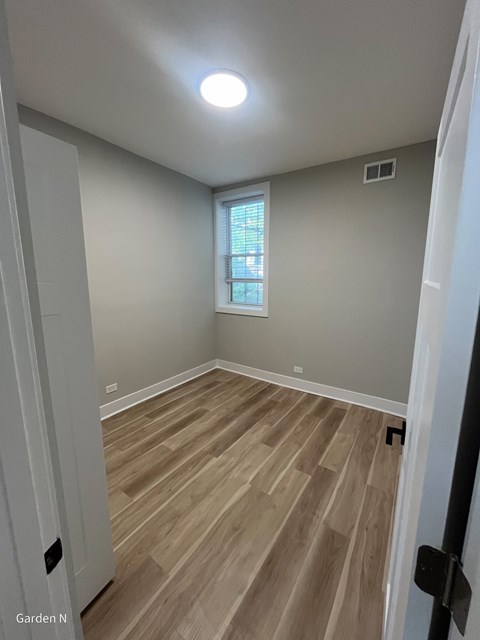 A room with wooden flooring and a window.