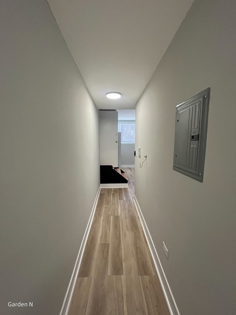 A long hallway with a dog on the floor.