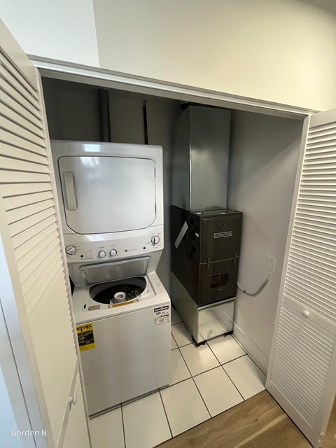 A white washing machine and dryer in a small laundry room.