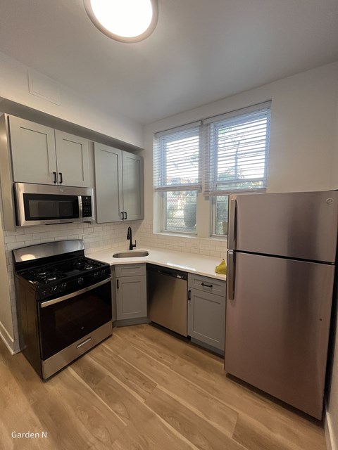 A kitchen with a stove, refrigerator, and cabinets.