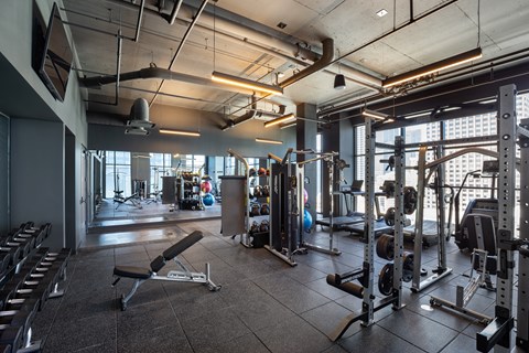 A gym with a variety of equipment including weights and machines.