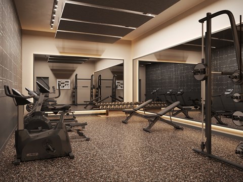 A gym with a variety of equipment including treadmills, weights, and exercise machines.