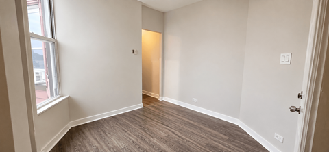 A room with a wooden floor and white walls.