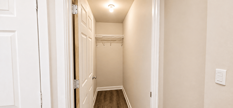 A hallway with a white door and a light on the wall.