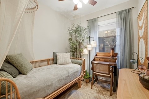 A bedroom with a bed, desk, and chair.
