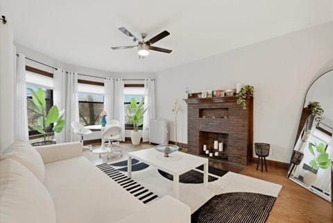A living room with a white couch and a fireplace.