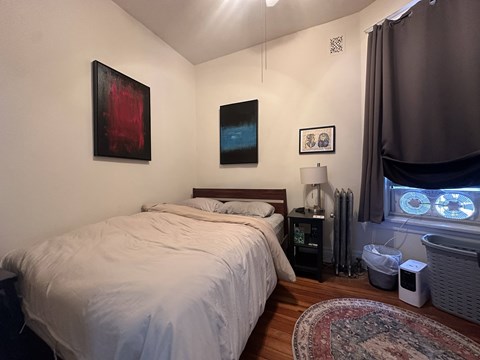 A bedroom with a large bed and a window with a view of the sky.