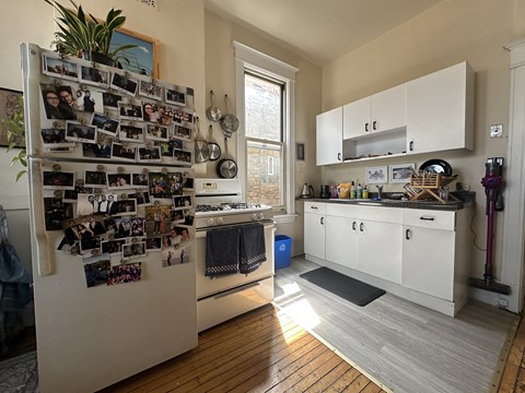 A kitchen with a refrigerator covered in photos.