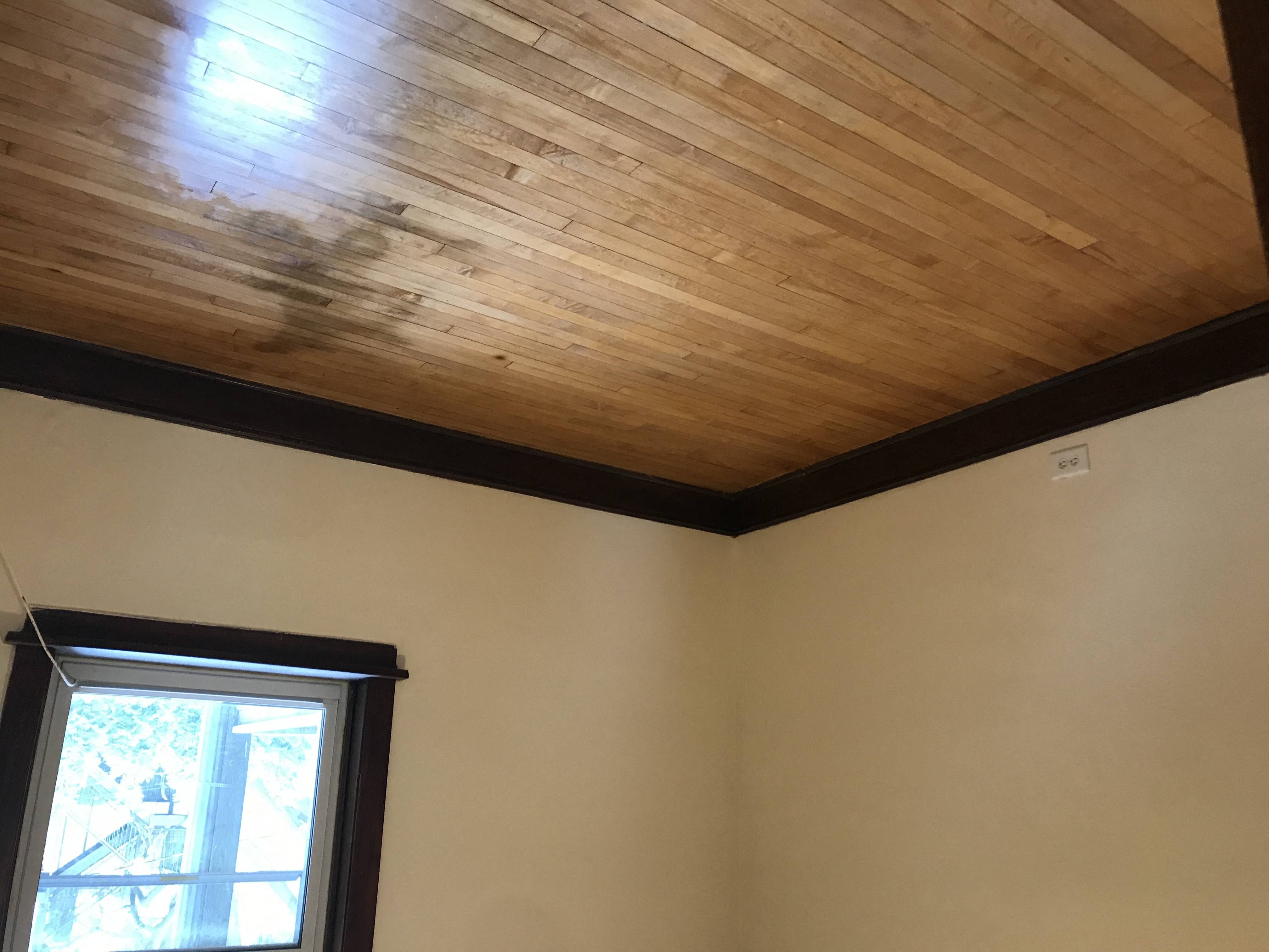 a room with a wooden ceiling and a window