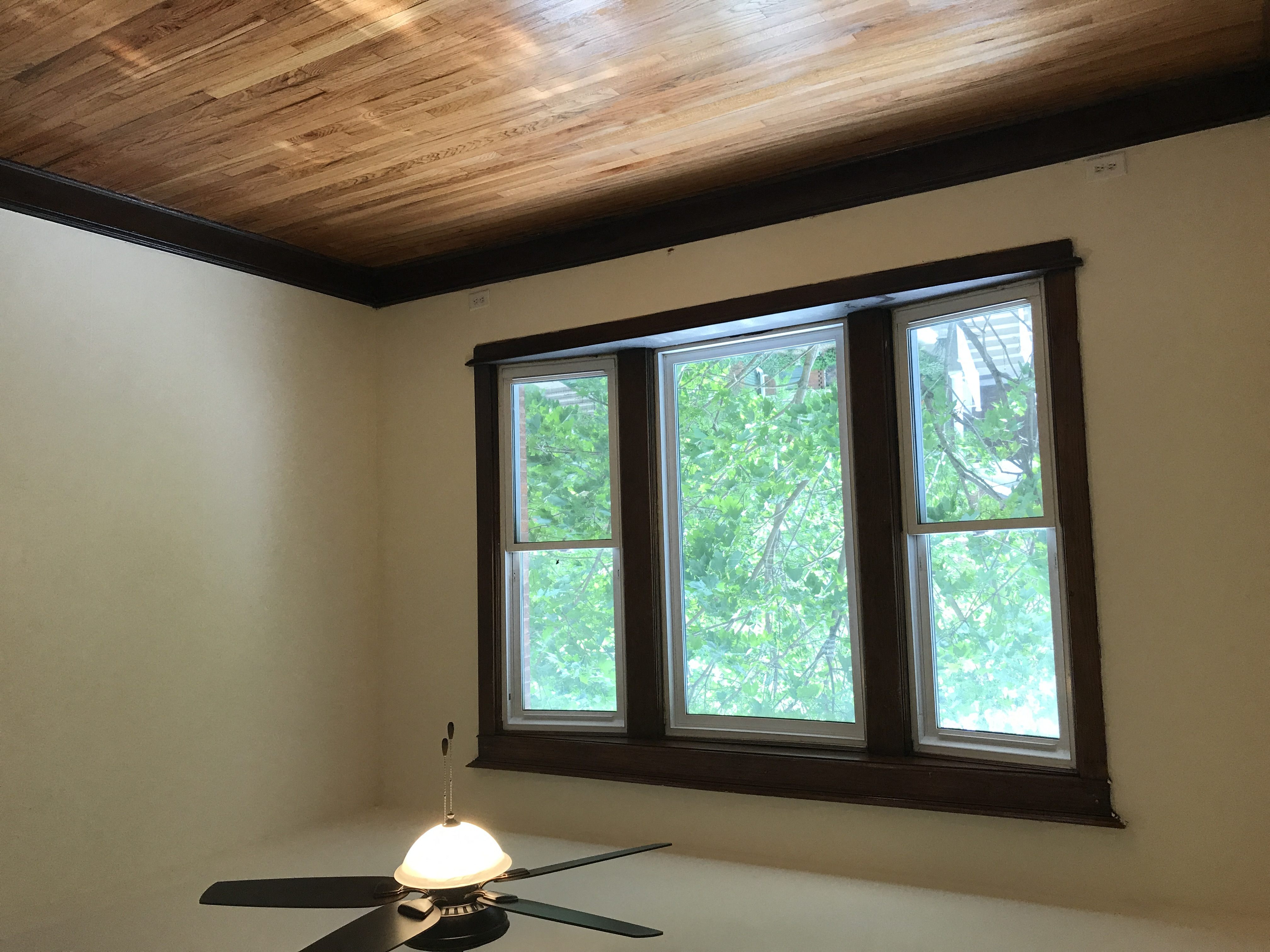 a living room with a large window and a ceiling fan