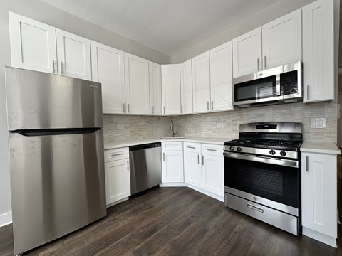 A kitchen with a stainless steel refrigerator, oven, and microwave.
