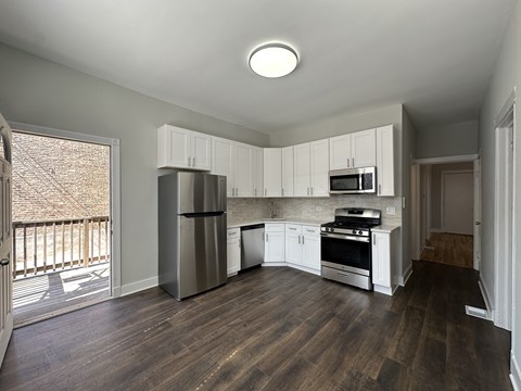 A kitchen with wooden floors and stainless steel appliances.